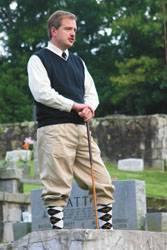 Three actors in period costume at a graveside